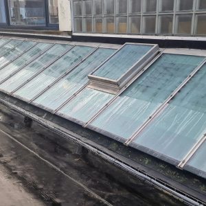 Glasservice op een glazen dak met schoonmaak en onderhoudsservice.