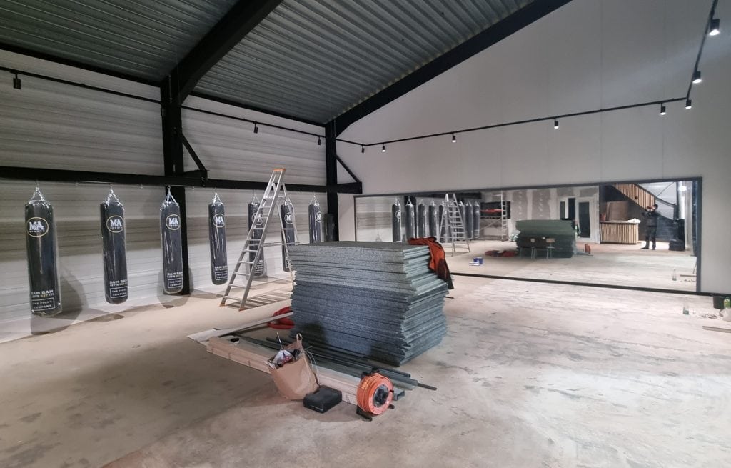 Nieuwe glazenwand installatie in voortgang bij Onderhoud- en Glasservice Bonn, glasplaten en isolatiepanelen klaar voor montage in een industriële ruimte.
